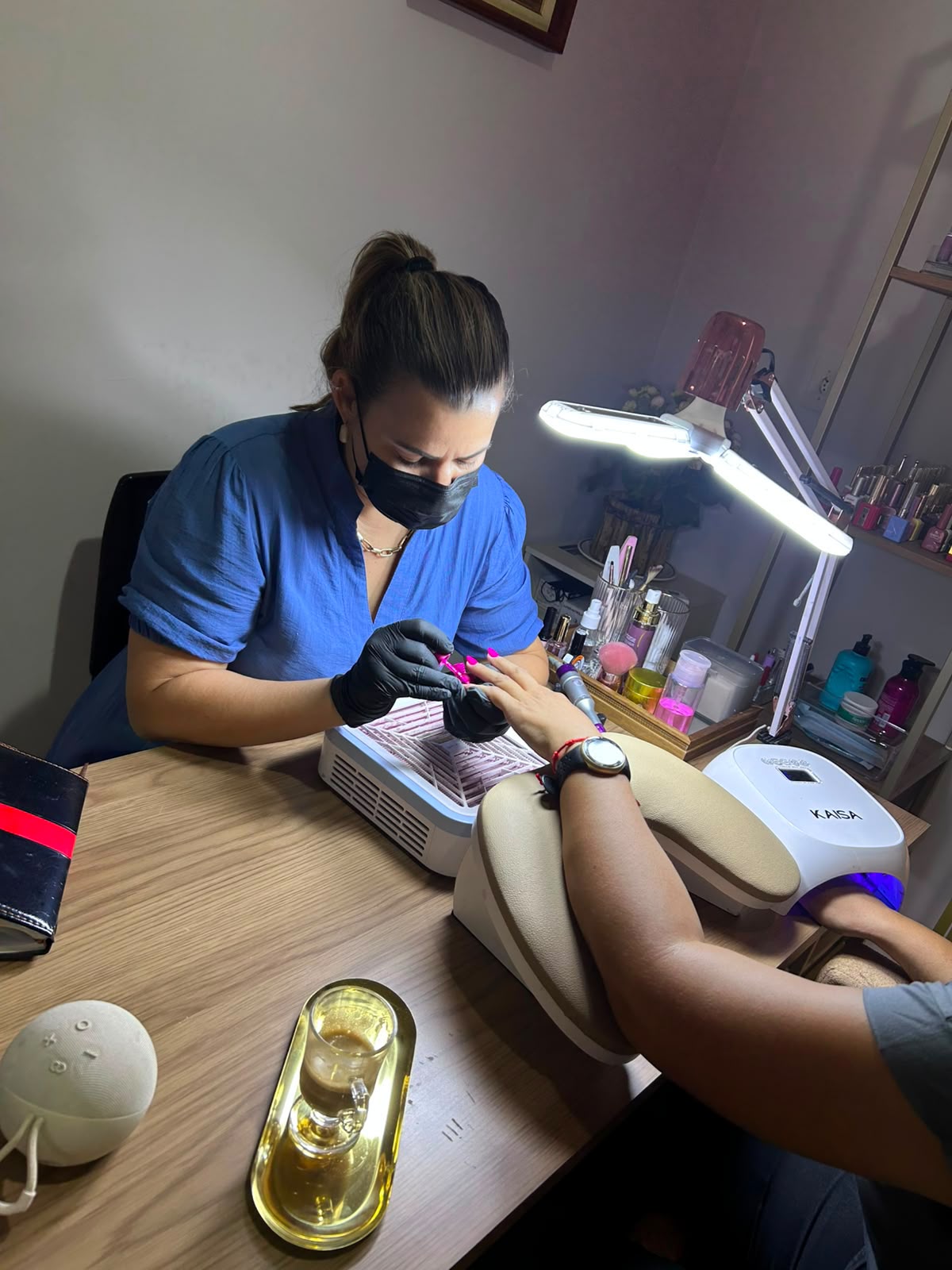 Gi Sensato realizando atendimento de unhas